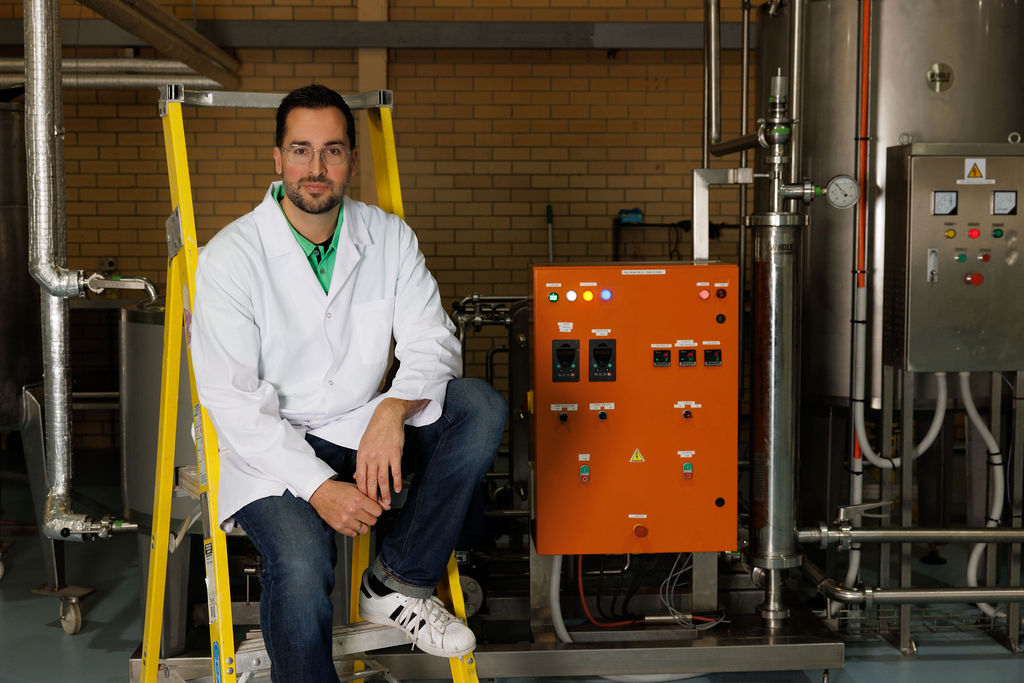 Startup founder seated beside agricultural processing equipment